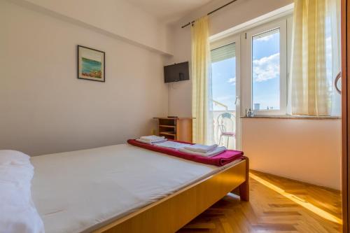 a bedroom with a bed and a large window at AKELAVA in Crikvenica