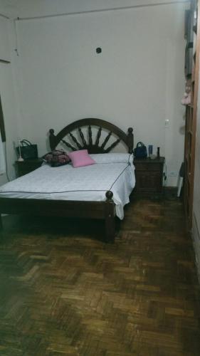 a bedroom with a bed and a wooden floor at Hermosa quinta para 8 personas in Moreno