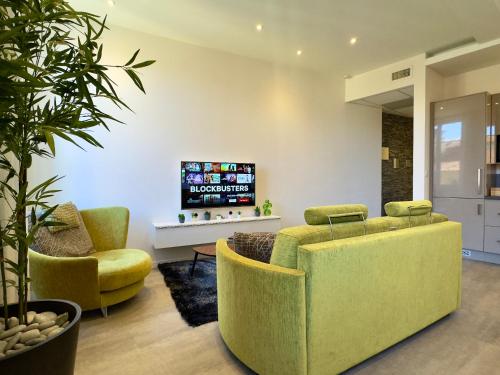 un salon avec deux chaises et une télévision dans l'établissement Eleganza By SCLS Locations, à Cannes