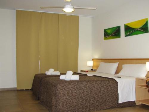 a bedroom with two beds and a ceiling fan at RCT Club vacacional y Spa in General Conesa