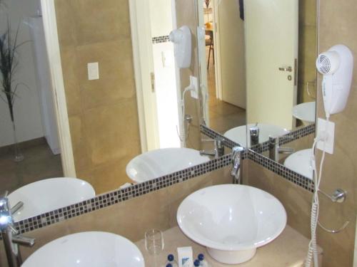 a bathroom with four sinks and a large mirror at RCT Club vacacional y Spa in General Conesa