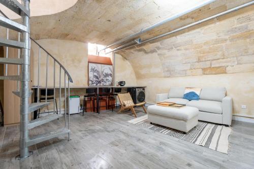 ボルドーにあるAppartement Bordeaux centre proche Tramwayのソファと階段のあるリビングルーム