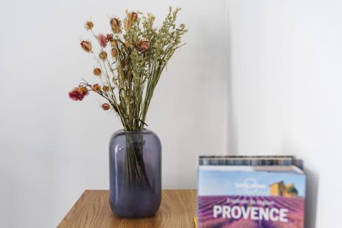 un vase bleu avec des fleurs assis sur une table dans l'établissement Appartement Sureau - Welkeys, à Avignon