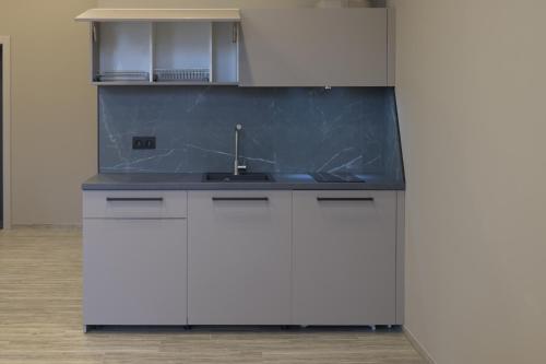 a kitchen with white cabinets and a sink at REST INN apart hotel in Cherkasy