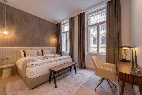 a bedroom with a large bed and a desk and window at josef's home I Superior Suite I Quiet & Central in Vienna