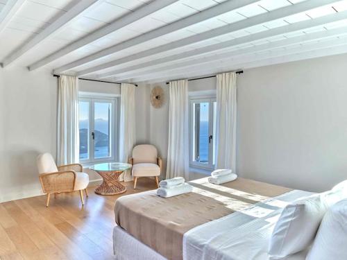 a bedroom with a bed and a table and windows at Villa Maera 3 in Kalo Livadi