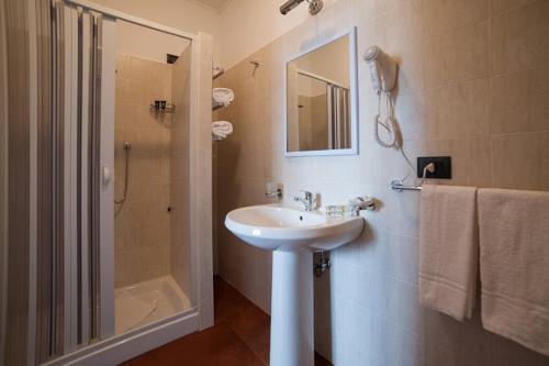 a white bathroom with a sink and a shower at Metropoli's in Taurianova