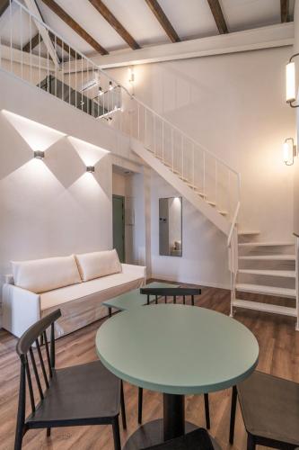 a living room with a table and a staircase at VLC HOST - Reina 168 in Valencia