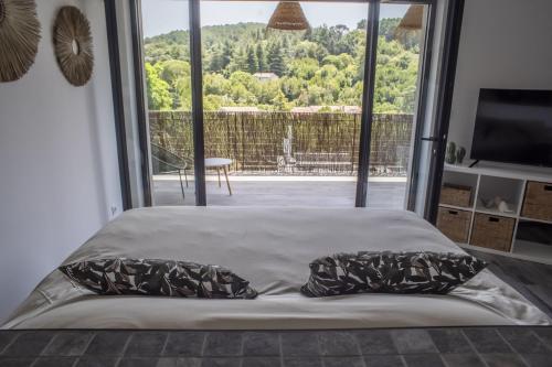 un lit dans une chambre avec une grande fenêtre dans l'établissement Villa Gianna Anduze, à Anduze