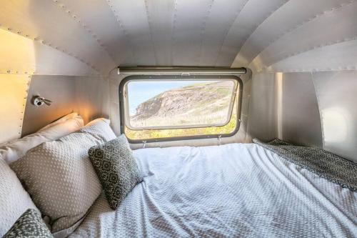 Una pequeña habitación con una cama y una ventana. en Airstream - Seabreeze Airstream Overlander in Pembrokeshire, en Haverfordwest