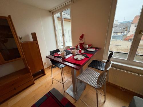une table à manger avec des chaises, une table et une fenêtre dans l'établissement Appart 3P 57 m2 Le Coeur de la Krutenau Strasbourg, à Strasbourg
