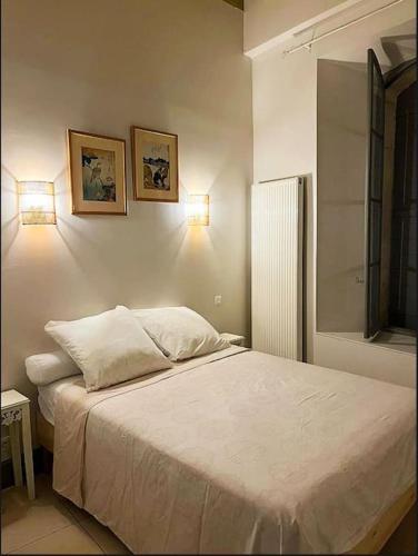 - une chambre avec un lit et deux lumières sur le mur dans l'établissement Appartement de charme au centre historique d'Arles, à Arles
