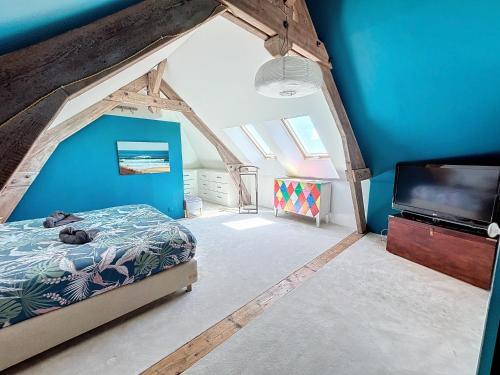 une chambre avec un lit et une télévision à écran plat dans l'établissement Gîte de la Brasserie, à Grandfresnoy