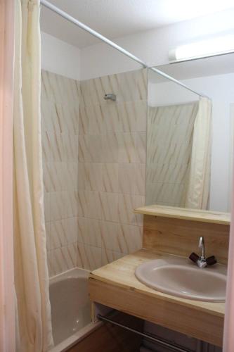 une salle de bain avec un lavabo, un miroir et une baignoire dans l'établissement Zénitude pour ce bien en front de mer avec parking privatif - 4LAG502, à Saint Cyprien Plage