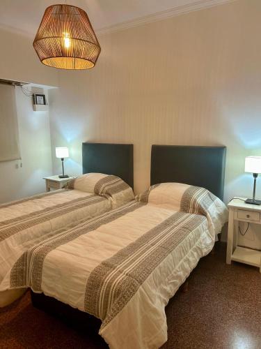 two beds sitting next to each other in a room at Natullins Apartment in Ezeiza