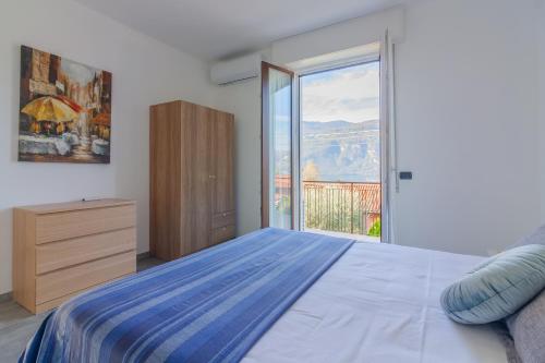 a bedroom with a bed and a large window at Sweet Caroline in Lierna