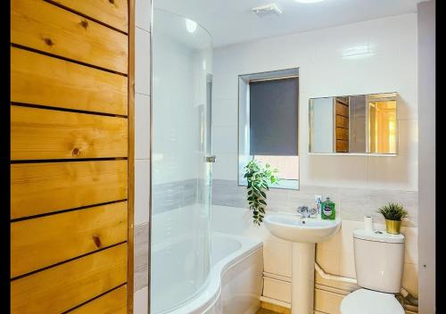 a bathroom with a sink and a tub and a toilet at Cambridge Apartment at St Neot in Eaton Socon