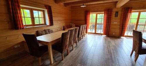 a dining room with a wooden table and chairs at Chalupa Pod Větrným Vrchem in Dolní Morava