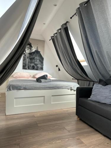 - une chambre avec un lit avec des rideaux et un canapé dans l'établissement Colmar City Center - Appartement BELLE-VUE 4 étoiles, à Colmar