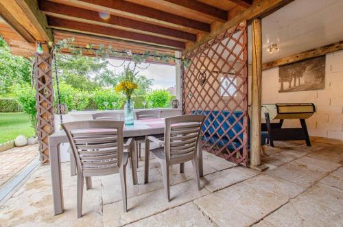 une table et des chaises sur une terrasse avec une fenêtre dans l'établissement Le p'tit nid de sissi, à Fouchères