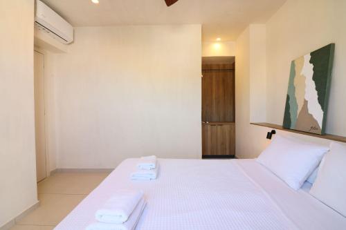a bedroom with a bed with two towels on it at Philoxenia Apartments in Panormos Rethymno