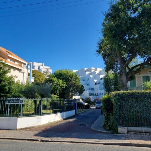 une rue de la ville avec une clôture et un bâtiment dans l'établissement ARCACHON PLAGE Centrale, à Arcachon