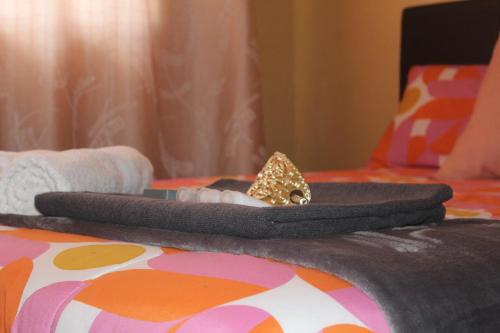 a hat with a butterfly on top of a bed at Self-catering rooms Florida in Roodepoort