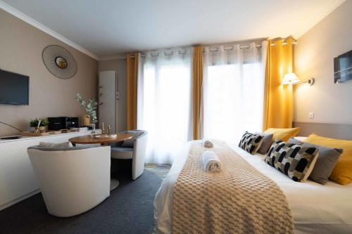 une chambre d'hôtel avec un lit, une table et une table dans l'établissement Paris Porte de Versailles Cosy Lodge 1 Appart hôtel parking wifi 4 pers, à Issy-les-Moulineaux
