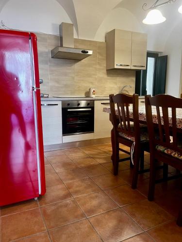 a kitchen with a red refrigerator and a table and chairs at Casa Cardi in Sperlonga