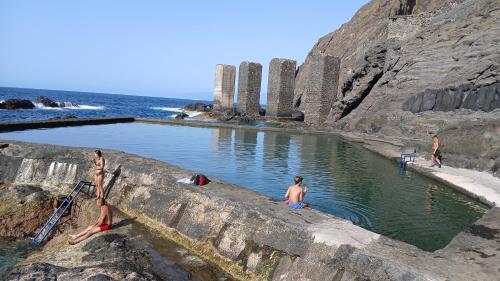 a group of people swimming in a pool in the ocean at Furgot3 in Agulo