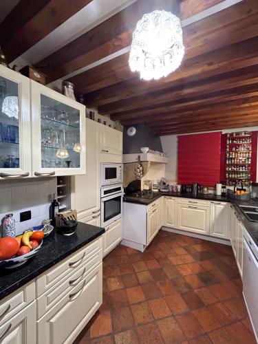 - une cuisine avec des placards blancs et un bol de fruits sur le comptoir dans l'établissement La maison de Brigitte aux petites avaizes, à Châteauneuf