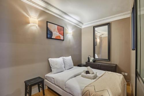 une petite chambre avec un lit et un miroir dans l'établissement Charming Apartment Center of Paris by Studio Prestige, à Paris