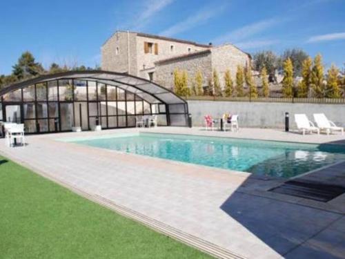 a large swimming pool in front of a building at Chambres d'hôtes à Pêtre in Entrevennes