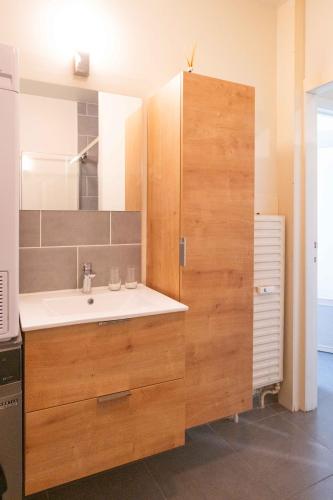 a bathroom with a sink and a large wooden cabinet at Ilot de paix in Ostend