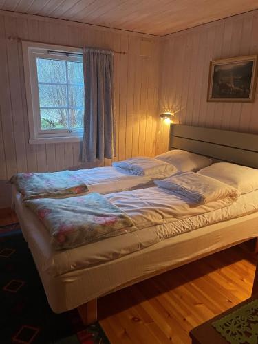 a large bed in a bedroom with a window at Briksdalsbre Fjellstove in Briksdalsbre