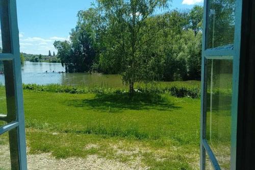 Elle offre une vue sur le lac depuis sa fenêtre. dans l'établissement Détente en Bord de Seine - Collection Idylliq, à Vétheuil