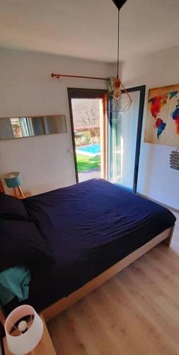 une chambre avec un lit bleu et une fenêtre dans l'établissement Entre Mer & Montagne !, à Levens