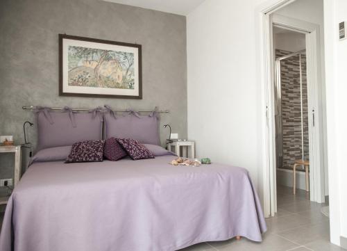 a bedroom with a bed with a purple bedspread at Il Nettare in Riomaggiore