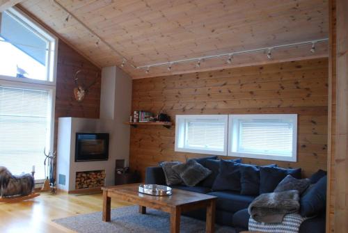 a living room with a blue couch and a table at Flott hytte på Smølåsen Tjørhom in Fidjeland