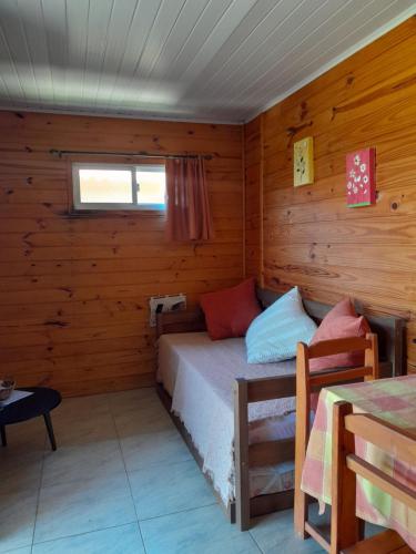 a bedroom with a bed in a wooden cabin at Itsasoa in Barra del Chuy