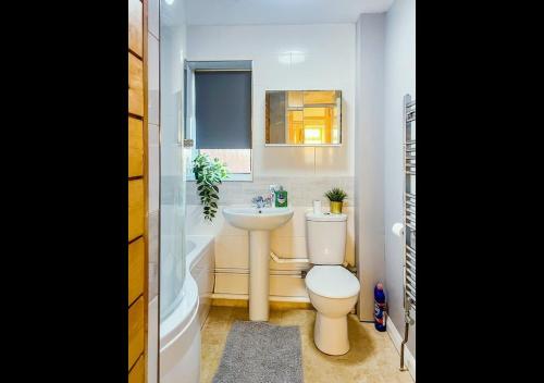 a bathroom with a toilet and a sink and a tub at Cambridge Apartment at St Neot in Eaton Socon
