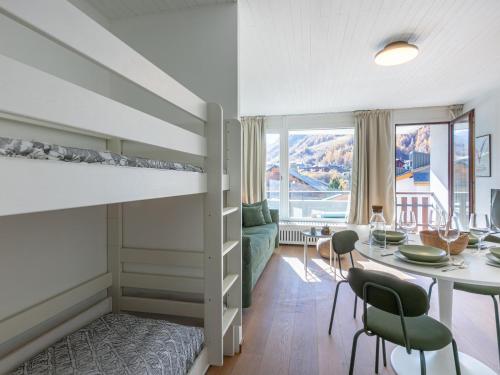 - une chambre avec des lits superposés, une table et des chaises dans l'établissement Studio cosy pour 4 avec balcon et wifi à Val-d'Isère - FR-1-694-364, à Val dʼIsère