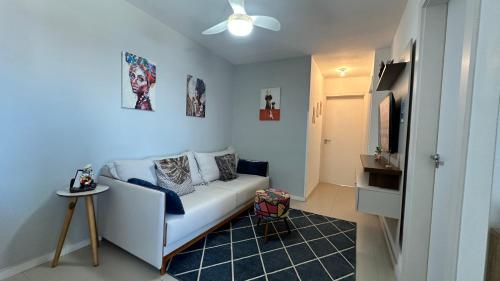 a living room with a white couch and a tv at Apartamento Espetacular Melhor Localização Praia Navega BC e Itajaí in Navegantes