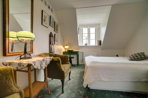 a bedroom with a bed and a table and chairs at Svostrup Kro in Silkeborg