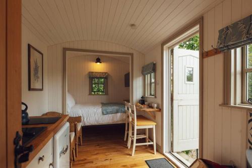 Un dormitorio con una cama, una mesa y un escritorio. en Shepherd's Hut - Jasmine, en Haverfordwest