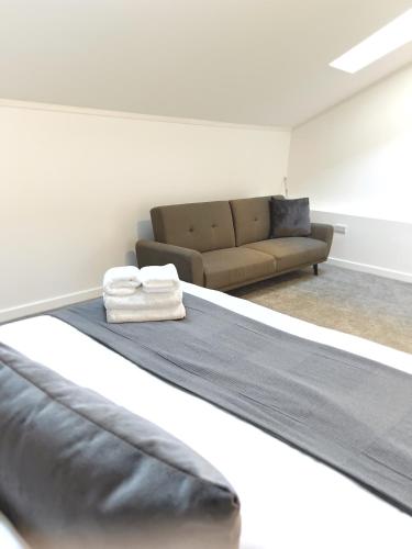 a living room with a couch and a bed at Ascot House Apartments in Peterborough