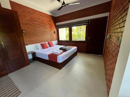 a bedroom with a bed and a brick wall at Coastal Hideaway in Midigama