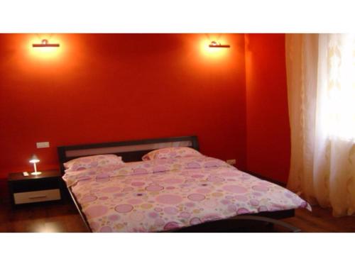 a bed in a room with a red wall at Studio Victoriei in Bucharest
