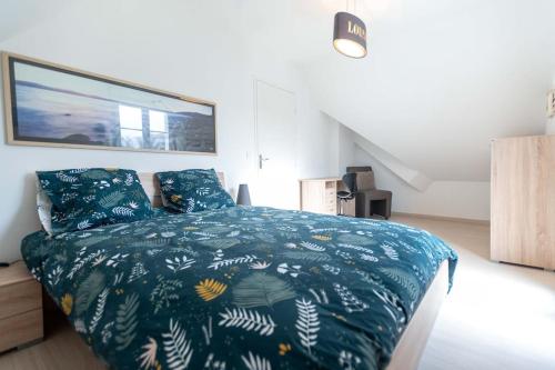 une chambre avec un lit avec une couette bleue dans l'établissement Ti Anna, à Carnac