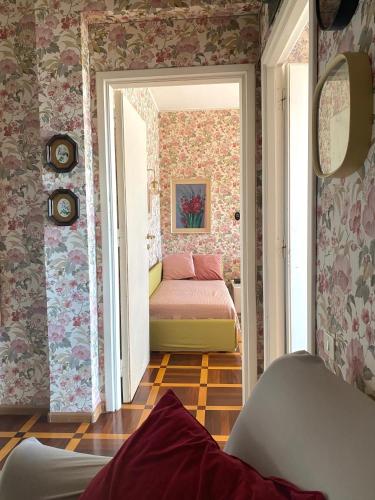a bedroom with a bed in a room with wallpaper at Via Roma a un passo dalle università! in Sassari